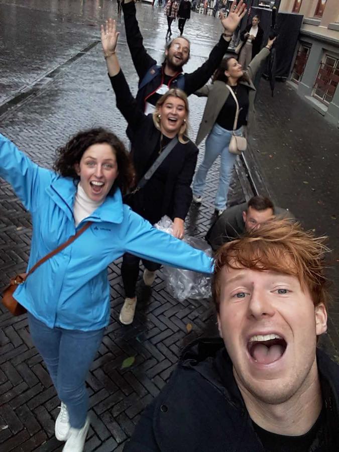 Een selfie van juichende collega’s van Diezit in een regenachtige straat