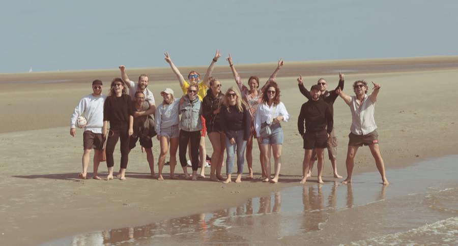 Het team van Diezit juichend op blote voeten op het strand