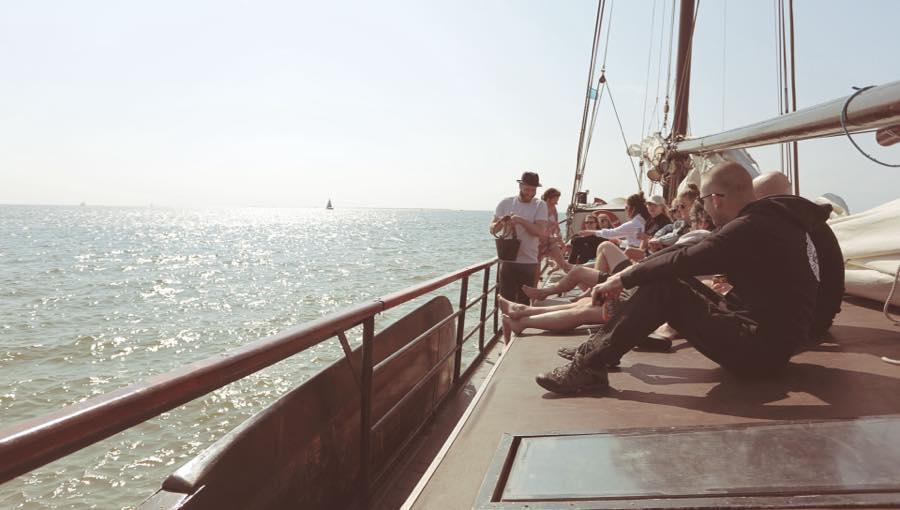 Collega’s van Diezit in de zon op het dek van een zeilschip